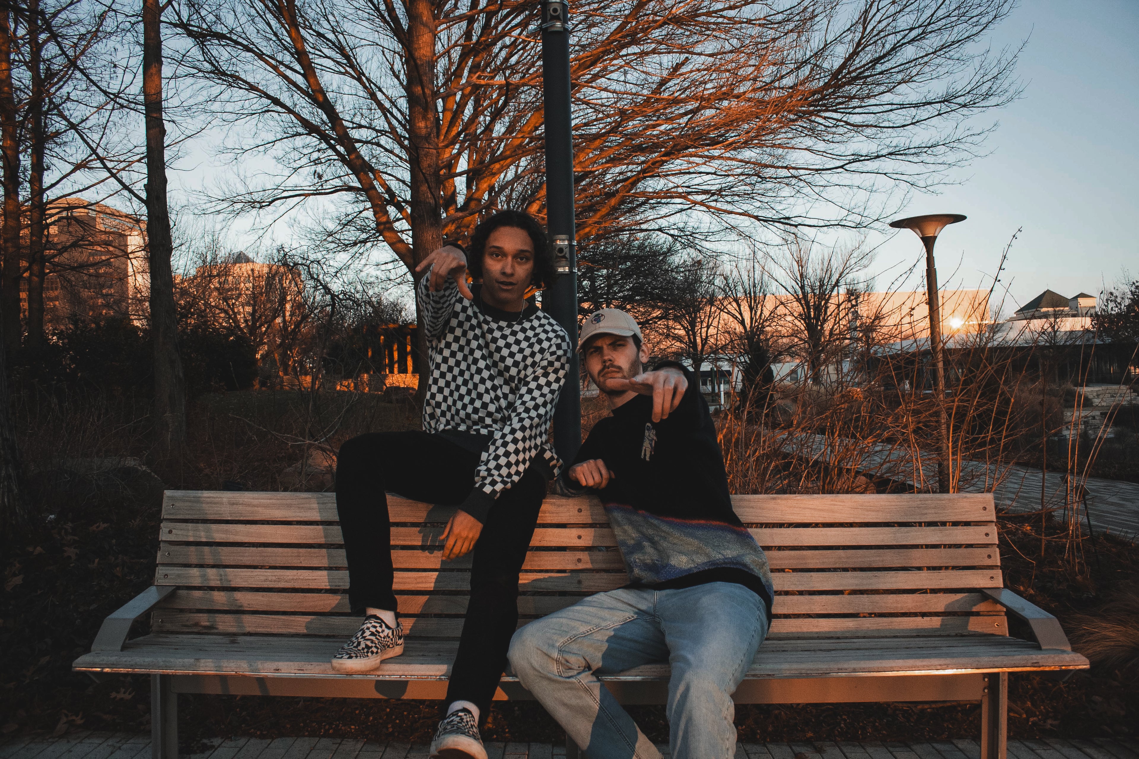 TruColours Apparel Jacquard knit sweaters (Checkered and Orbiter Sweater) being modeled by Aiden (left) and Blaine (right) on a random park bench [like Mordecai and Rigby].