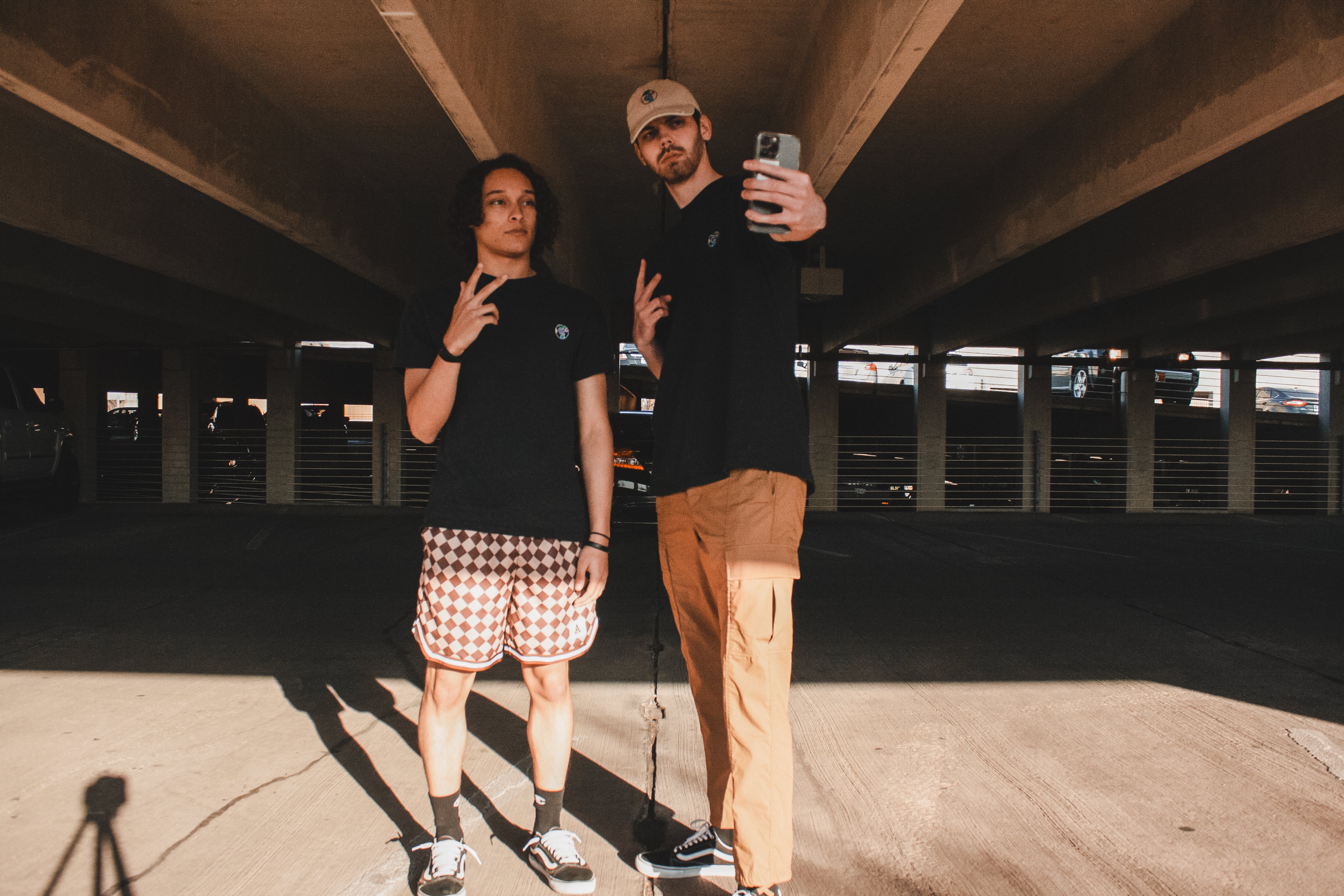 TruColours Apparel Embroidered T-Shirts being modeled by Aiden (left) and Blaine (right) in a parking garage. They are posing as if they are taking a selfie (Blaine holding the phone camera).